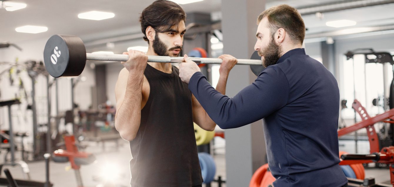 Indian man doing excercisses on special equipment at gym with pe